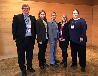 One man, four women pose in an empty room after receiving their award for records management.